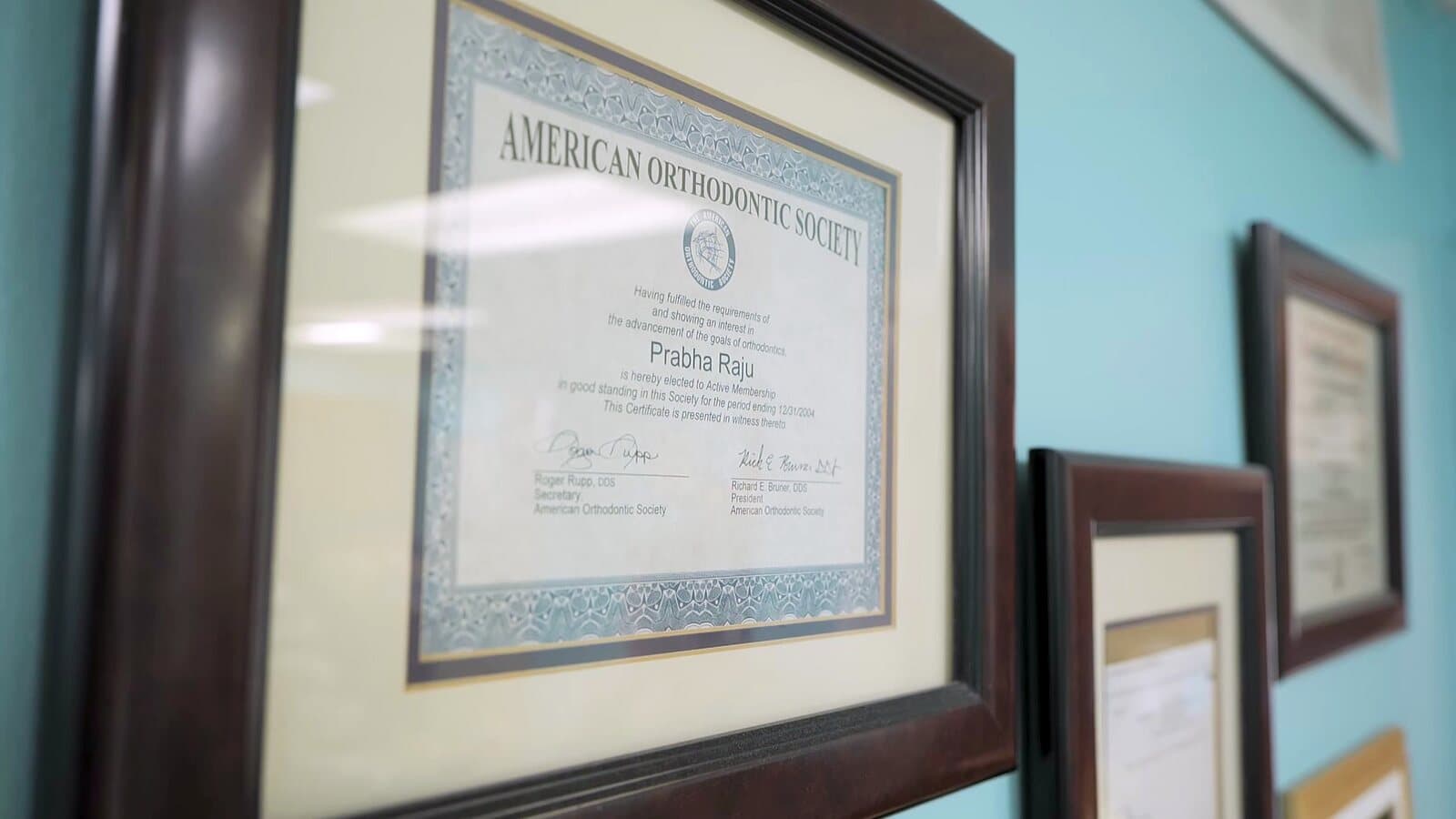 Framed certificates and credentials on the wall at Tender Dental Care