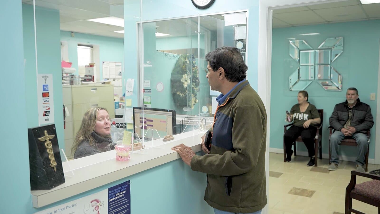 A patient checking in at the Tender Dental Care front desk