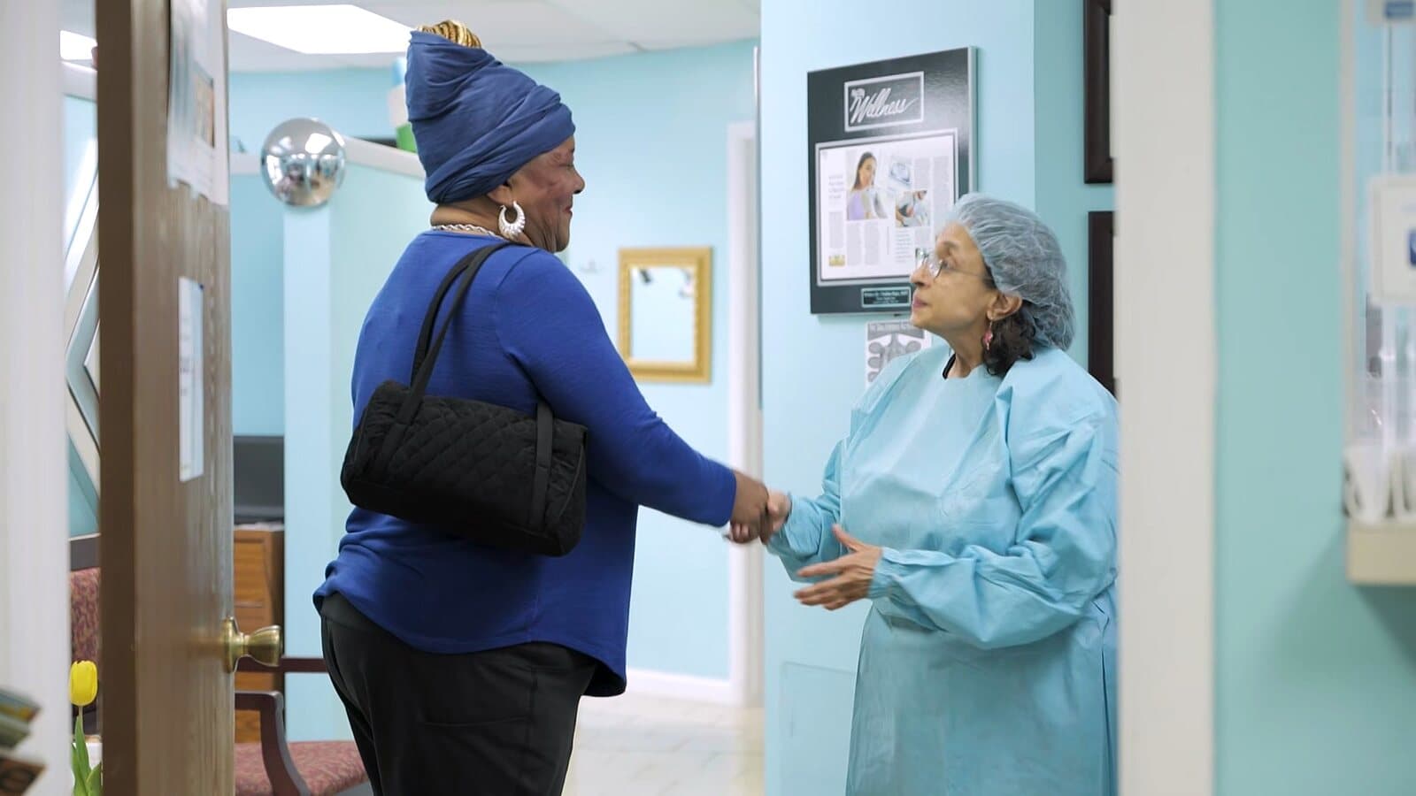 Dr. Raju greeting a patient with a handshake in the hallway